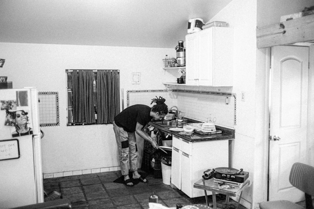 a black and white photo of a man in a kitchen