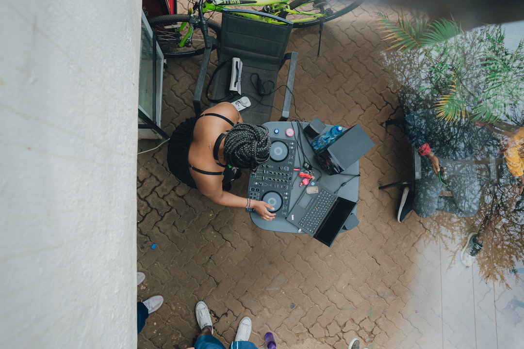 Dj playing music outdoors with a laptop and equipment.